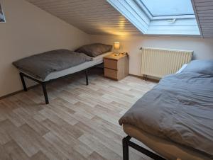 a bedroom with two beds and a skylight at Ferienwohnung Pusteblume in Marktbergel