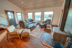 un soggiorno con divano, sedie e finestre di Madison Anglers House a Cliff Lake