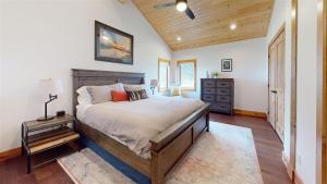 una camera da letto con un letto grande e un soffitto in legno di Madison Anglers House a Cliff Lake