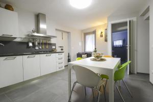 cocina con mesa blanca y sillas verdes en Casa Vacanze Vicolo della Luna, en Ambra