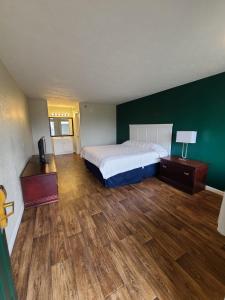 um quarto com uma cama e uma parede verde em Mississippi Hotel em Macon