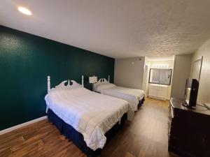 Duas camas num quarto com uma parede verde em Mississippi Hotel em Macon