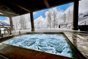 einen Whirlpool auf einer Terrasse mit schneebedeckten Bergen in der Unterkunft Wild Horse Meadows in Eden