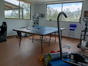 a gym with a table and some exercise equipment at BellaVista Casa de Montaña in Latacunga