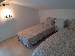1 dormitorio con 2 camas y una lámpara en la pared en Gite 4/6 pers près du Lac en pleine nature en Carcassonne