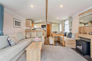 a living room with a couch and a table at 2 Bed 6 Berth Lodge in Shorefield Oakdene Dorset in Ferndown