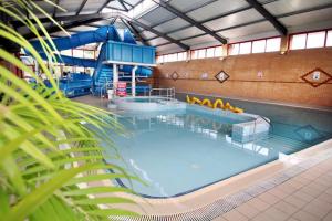 a large indoor swimming pool with a water slide at 2 Bed 6 Berth Lodge in Shorefield Oakdene Dorset in Ferndown