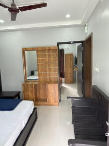 a bedroom with a bed and a mirror on the wall at Koshar Live in Kalpetta