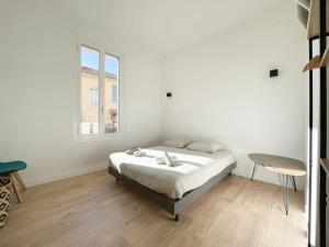 een witte slaapkamer met een bed en een raam bij Maison abba trois pièces in Saint-Antoine