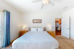 een slaapkamer met een wit bed en een plafondventilator bij Hooked on the Cape in Indian Pass