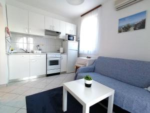 a living room with a blue couch and a table at Apartments Miha in Krk