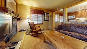 een woonkamer met een bank en een tafel bij Trapper Condo Unit 7 in West Yellowstone