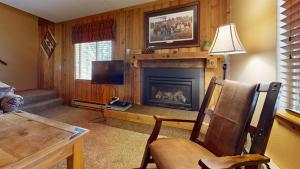 sala de estar con chimenea y TV en Trapper Condo Unit 7 en West Yellowstone