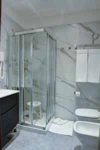 a bathroom with a glass shower and a toilet at Arsenale Turin Rooms in Turin