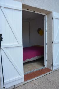 una porta che porta in una camera con un letto all'interno di Maison avec 2 terrasses à 400 mètres de la plage a Le Barcarès