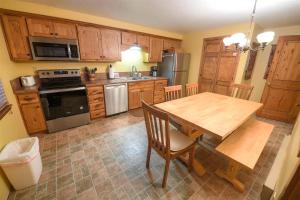 uma cozinha com uma mesa de madeira e uma sala de jantar em Trapper Condo Unit 3 em West Yellowstone
