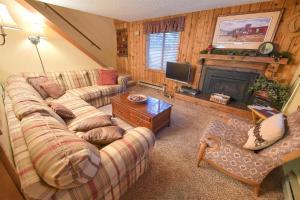 sala de estar con sofá y chimenea en Trapper Condo Unit 3 en West Yellowstone