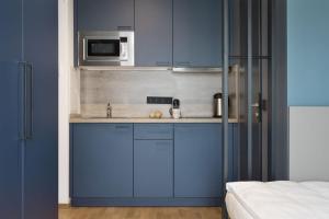 una cucina blu con lavandino e forno a microonde di Brera Serviced Apartments Singen a Singen