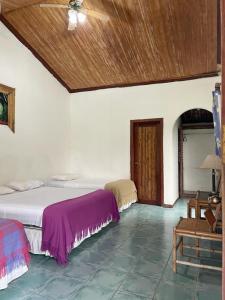 a bedroom with two beds and a wooden ceiling at HOSTERIA EL PARAISO in Pedro Vicente Maldonado