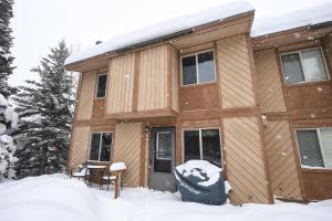 uma cabana na neve na floresta em Trapper Condo Unit 5 em West Yellowstone