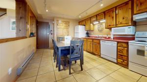 a kitchen with wooden cabinets and a table and chairs at Trapper Condo Unit 5 in West Yellowstone