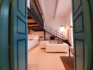 ein Wohnzimmer mit weißen Möbeln und einer Treppe in der Unterkunft Casa Cubino in Gioiosa Marea