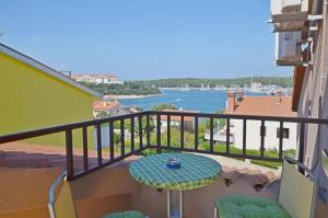 a balcony with a table and a view of the water at Apartments and Rooms Viktorija in Vinkuran