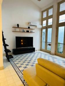 een woonkamer met een bank en een televisie bij Best Location - Beautiful and Amazing Loft in Panama-Stad