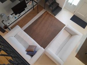 einen Blick über ein Wohnzimmer mit zwei weißen Sofas in der Unterkunft Casa Cubino in Gioiosa Marea