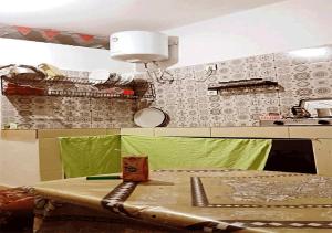 una cucina con tavolo e luce sul muro di 1A private room in a shared house for surfers a Safi