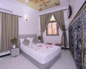 Un dormitorio con una cama blanca con flores. en Hotel Riad Fantasia, en Marrakech