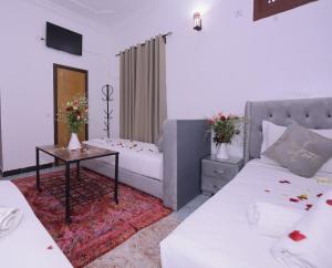 a living room with two beds and a table at Hotel Riad Fantasia in Marrakech