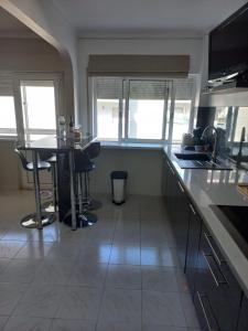 uma cozinha com um balcão, uma mesa e cadeiras em Casa Alves em Palmela