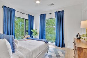 a bedroom with blue curtains and a large window at Hyve - Nashville Hideaway - Walk To Broadway in Nashville
