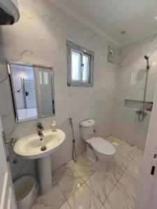 Baño blanco con lavabo y aseo en Lovely Suite en Yeda