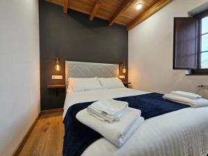 a bedroom with a large bed with towels on it at Apartamentos Rurales Lola Penarronda in Castropol