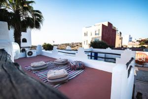 a patio with mats and umbrellas on a roof at Riad Dar Sarah in Taghazout +106 photos
