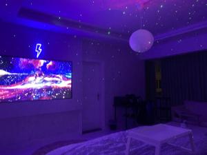 Habitación púrpura con TV en la pared en Lovely Suite en Yeda