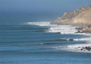 a group of waves in the ocean near a mountain at 1A private room in a shared house for surfers in Safi