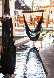 una hamaca está colgando sobre una piscina de agua en Bahia Tolok, en Isla Mujeres