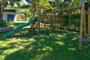 a playground with a slide in a park at Jaco Beach Villa Arenas Condo in Jacó