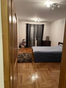 um quarto com 2 camas e piso em madeira em Apartman SARA em Sarajevo