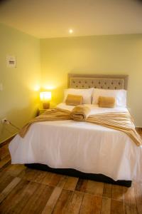 a bedroom with a large white bed with two pillows at loft grupo y parejas AZUCENAS in Jardin +18 photos