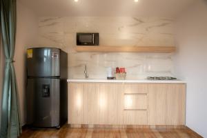 a small kitchen with a refrigerator and a sink at loft grupo y parejas AZUCENAS in Jardin
