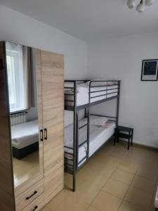 a room with two bunk beds and a mirror at Rooms4Rest Popularna - Private rooms for tourists - ATR Consulting Sp, z o,o, in Warsaw