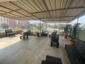 a large patio with chairs and tables and windows at 33 Hotel Bulerias in Medellín