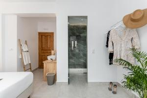 um quarto com paredes brancas, uma cama branca e um closet em Golden Bird's em Naxos Chora