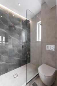 uma casa de banho com um WC e uma cabina de duche em vidro. em Golden Bird's em Naxos Chora
