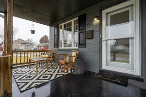 a porch with a table and chairs on a house at Charm City Hideout 2bdr and Basement in Indianapolis