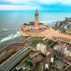 a building with a clock tower next to the ocean at MARINA APARTMENT OCEAN VIEW in Casablanca